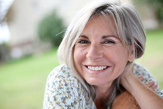 Smiling woman with a full smile after getting dental implants